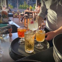 Different cocktails are arranged on a waiter's tray